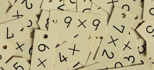Pequenos pedaços de papel com operaçõe matemáticas, como 9 vezes 9
