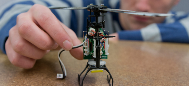 Na imagem vemos uma mão segurando um robô em construção