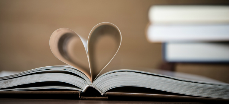 Livro aberto com folhas dobradas formando um coração