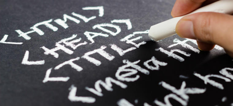 Código HTML sendo escrito com giz em uma lousa