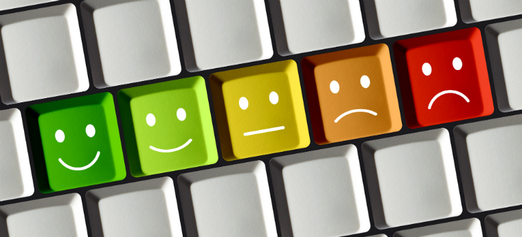 Teclado de computador com teclas verdes com expressões de alegria, tristeza e monotonia