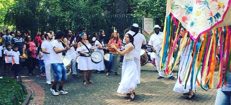 Pessoas caminham na rua durante cortejo