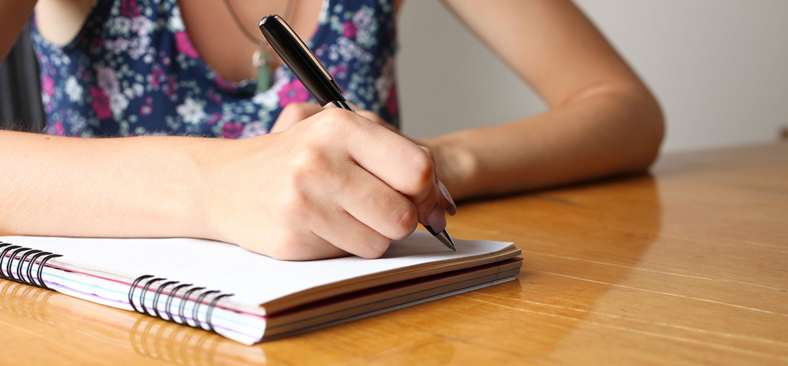 menina escreve em um caderno