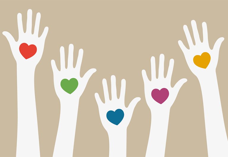 Braços erguidos com corações desenhados nas palmas das mãos