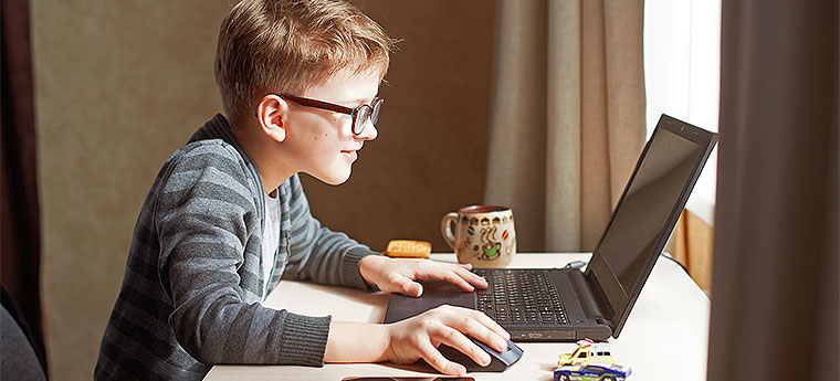 Criança com óculos mexendo em computador