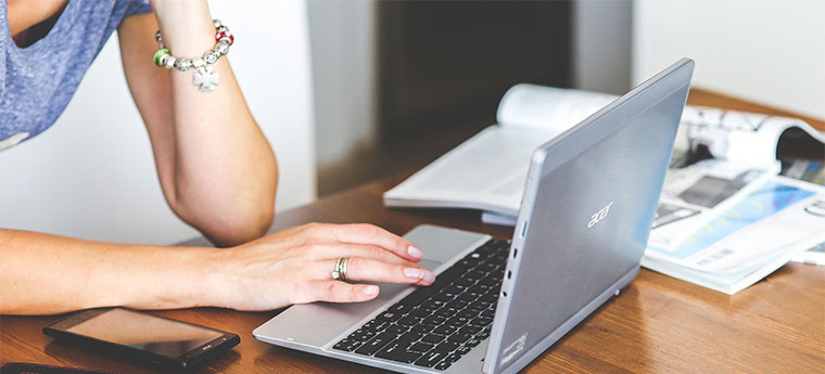 Mulher usa computador em casa