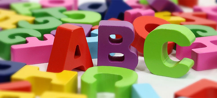 Letras A B e C em destaque com outras dispostas sobre uma mesa