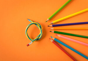 Lápis coloridos com um lápis flexível no fundo alaranjado