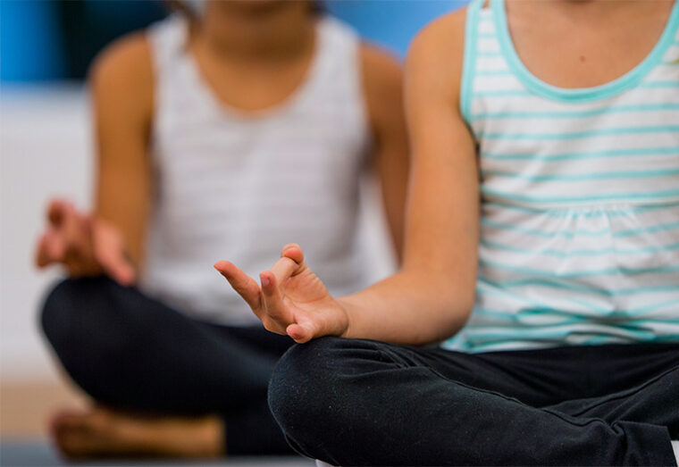 Duas crianças sentadas em posição de meditação