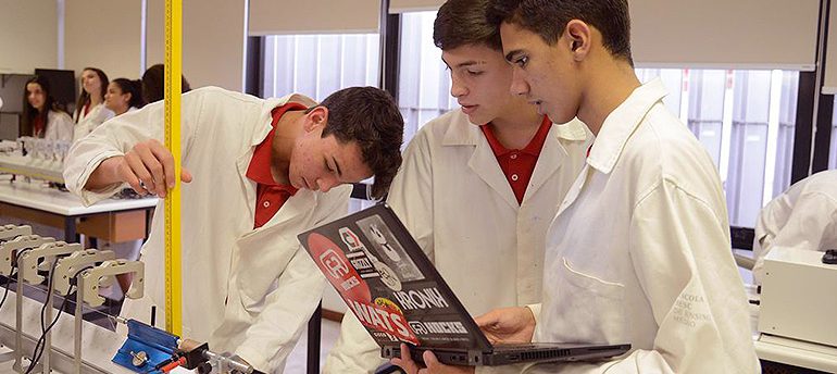 Estudantes em um laboratório analisam equipamento