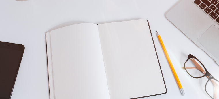 caderno com computador e celular ao lado