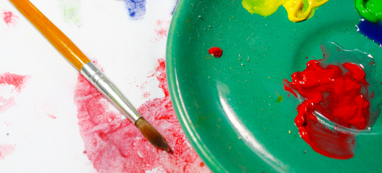 pincel e tintas espalhadas em um prato