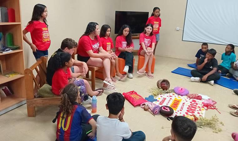 Jovens se apresentam para crianças em uma biblioteca, com foco em temas de valorização do corpo e educação.
