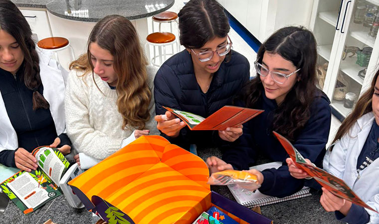 Grupo de estudantes folheia materiais da Central da COP em laboratório