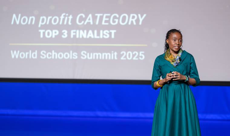 Rapelang Rabana durante apresentação em palco com tela ao fundo indicando que é finalista na categoria sem fins lucrativos