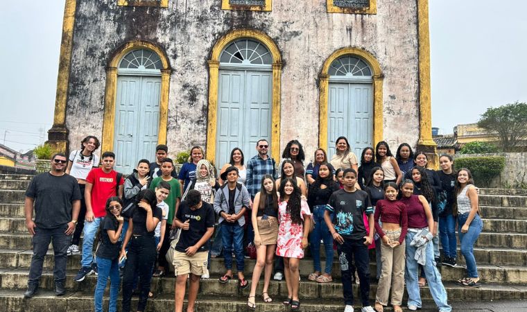 Grupo de estudantes e professores em escadaria de igreja antiga